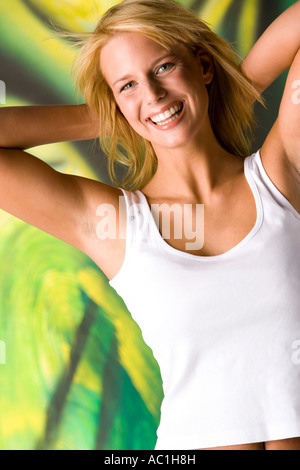 Blonde Frau strahlend vor Freude die Hände hinter dem Nacken Stockfoto