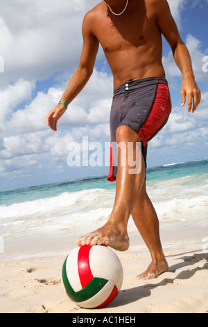 Junger Mann, Fußball am Strand Stockfoto