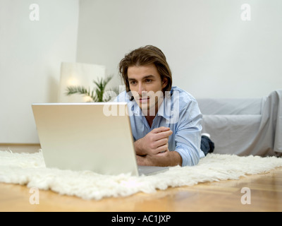 Mann liegt am Boden, mit laptop Stockfoto