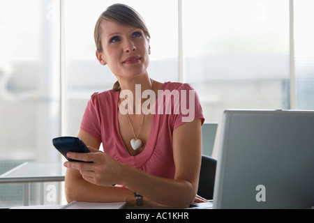 Business-Frau mit einem Palmtop, am Schreibtisch Stockfoto