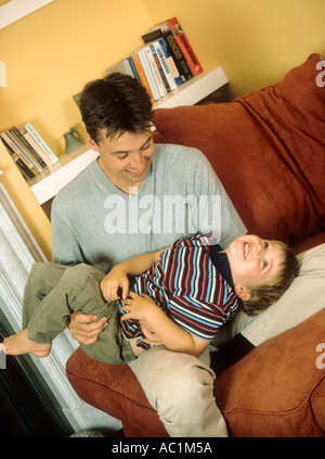 Vater spielen rau und Wäschetrockner mit seinem Sohn im Haus Stockfoto