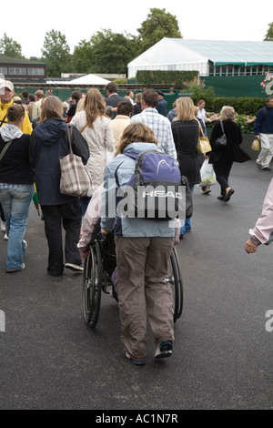 Frau im Rollstuhl geschoben in Wimbledon Tennis Championship UK Stockfoto