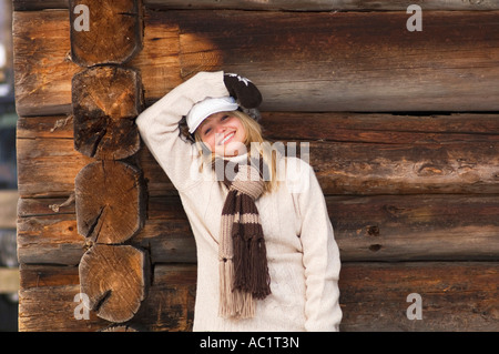 Junge Frau stützte sich auf Holzwand Stockfoto