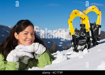 Frau mit Schneeschuhen im Schnee liegend Stockfoto
