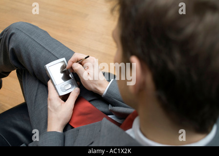 Geschäftsmann mit seinem palmtop Stockfoto