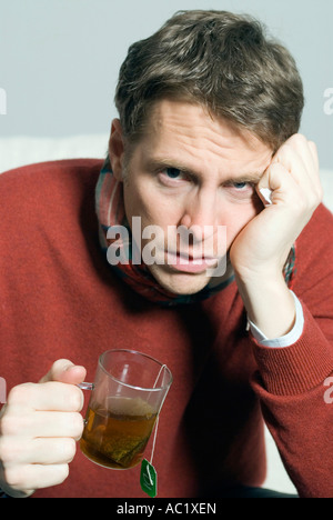 Mann mit Kälte eine Teetasse in Händen Stockfoto