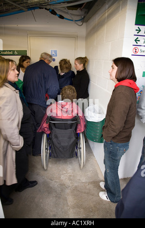 Behinderte Zuschauer im Rollstuhl / Rollstuhl in die Warteschlange für WC / Toilette / WC im Wimbledon Tennis Championship. London UK. Stockfoto