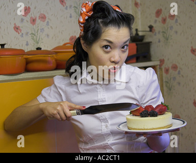 Marianne Cheesecake chinesisches Mädchen hält eine Käsekuchen mit Erdbeeren und Brombeeren auf einem Teller dekoriert Stockfoto