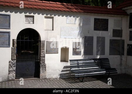 Bank und das Typenschild Gedenkstätten für jüdische Familien, die unter anderem während des Holocaust in Englisch Hebräisch in Remuh getöteten Tor Stockfoto