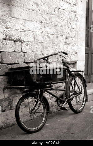 Altes Fahrrad an einer Steinmauer gelehnt Stockfoto