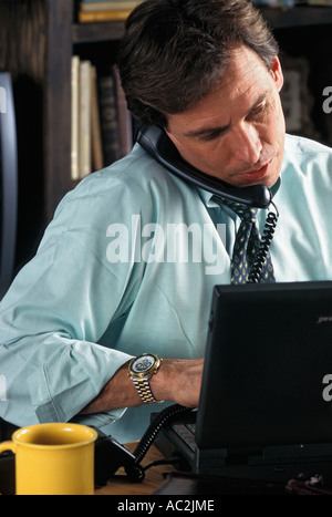 Kaukasische Geschäftsmann am Telefon arbeiten auf Laptop-computer Stockfoto