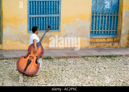 Mann, Simon Bolivar hinunter und tragen ein Cello, Trinidad, Kuba. Stockfoto