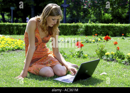 junge Frau trägt einen Sommerrock im Park in ihr Notizbuch, Österreich Stockfoto