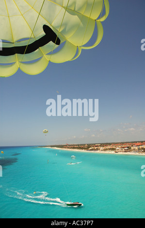 Ein Parasail steht im Vordergrund als das blaue Wasser des Golf von Mexiko liegen unten vor der Küste von Playa del Carmen, Mexiko. Stockfoto