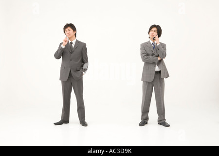 Zwei junge Geschäftsleute sprechen auf dem Handy Stockfoto