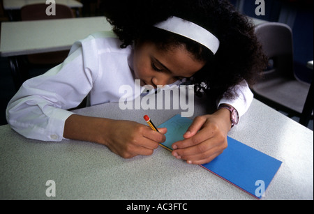 Geheimnisse, die kleinen schwarzen Schulmädchen eine geheime Notiz schreiben Stockfoto