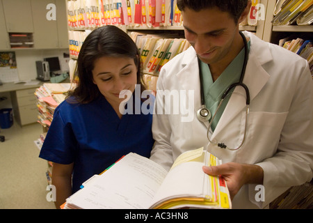 Porträt des jungen Arzt und Krankenschwester mit Blick auf medizinische Diagramme Stockfoto