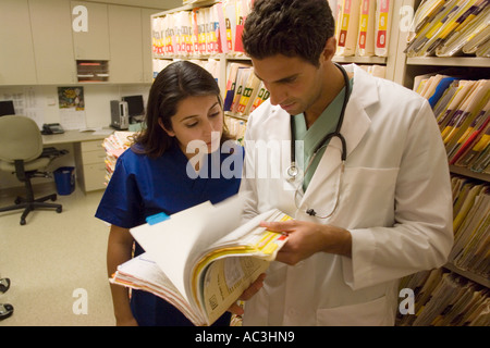 Porträt des jungen Arzt und Krankenschwester mit Blick auf medizinische Diagramme Stockfoto