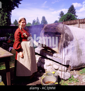 Frau-Re-Enactor Brotbacken im alten Outdoor Backofen bei Fort Langley National Historic Site, BC, Britisch-Kolumbien, Kanada Stockfoto