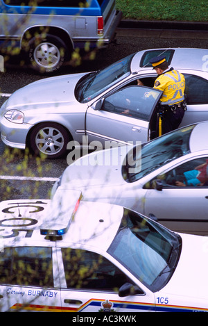 Schreiben ein Ticket für Verletzung Verkehrsstörung auf Autofahrer fahren in einem Auto Polizist Stockfoto