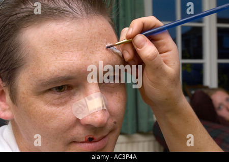 Make-up Artist arbeiten an Schauspieler in der Film Anwendung Fake Blood und Stockfoto