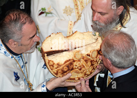 Orthodoxe Priester brachen das Brot während der Heiligen Kommunion am Saint Spasoje oder Spasovdan, Banja Luka, Bosnien-Herzegowina Stockfoto