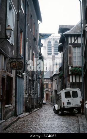 Launisch Schuss von einer Seitenstraße in der Altstadt von einer französischen Stadt mit einem Citroen 2CV Lieferwagen geparkt Stockfoto