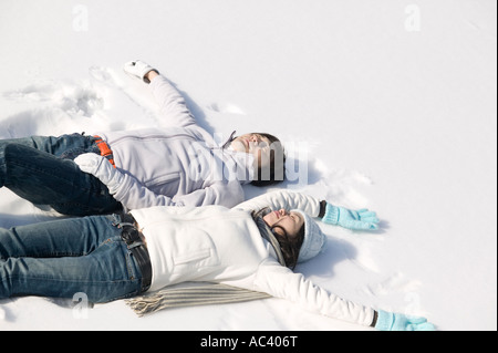 Junges Paar auf Schnee liegen Stockfoto