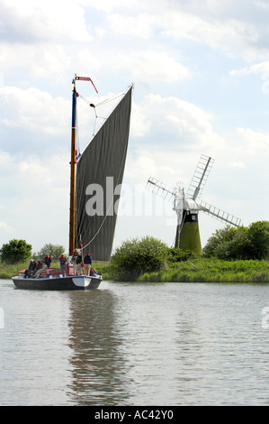 Wherry Boot Vergnügungsschiff auf Norfolk Broads mit Windmühle im Hintergrund Mai Stockfoto