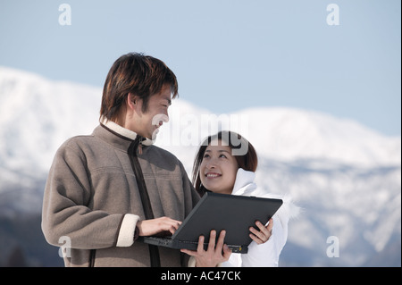 Junges Paar mit Computer außerhalb Stockfoto