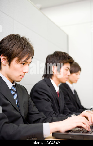 Drei junge Geschäftsleute, die mit dem Computer Stockfoto