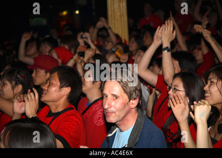 Westlichen Kerl sitzt unter South Korea (Republik) Fans beobachten 2006 WM-Finale gegen Frankreich, Cafe de Paris, London Stockfoto