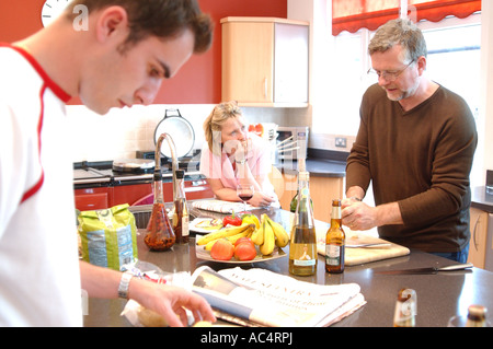 Britische Familie in Küche zu Hause machen Mittagessen zusammen und plaudern in London UK Stockfoto