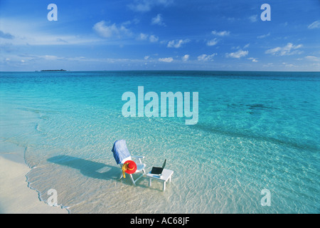 Stuhl und Tisch mit Laptop und Handy am Strand auf den Malediven vertreten arbeiten Urlaub Stockfoto