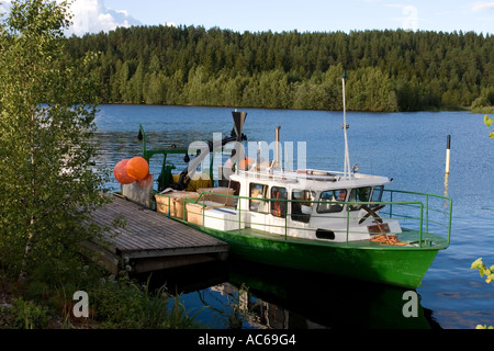 Kleiner grün-weißer finnischer Binnensee-Trawler, der an einem Pier, Finnland, ankert Stockfoto