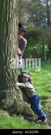 Mutter und Kind umarmt Eiche Quercus rober Stockfoto
