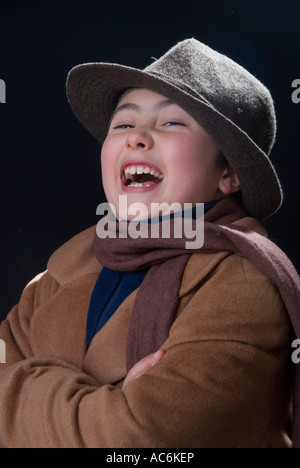 Kleiner Junge in warmen Mantel trägt einen Schal und Fedora Hut lachen Stockfoto