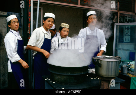 Junge Hui Männer kochen Nudeln zu essen stand auf dem Markt von Xian, die Hauptstadt der Provinz Shaanxi in zentral China Stockfoto