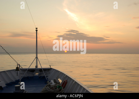 Sonnenuntergang in der Ionischen Meer Sonne taucht den Horizont vom Bug des Kreuzfahrtschiffes aus gesehen Stockfoto