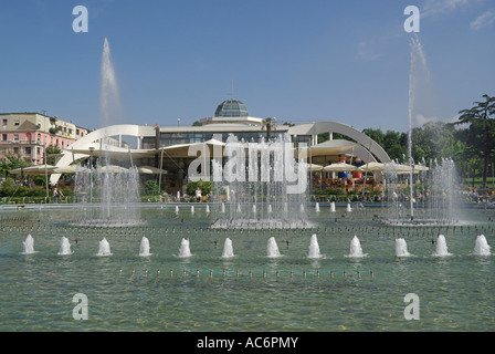 Republik Albanien Tirana Wasserspiele & Brunnen Anzeige an Taiwan Center Restaurant komplex Menschen sitzen draußen im Schatten des weißen Sonnenschirmen Stockfoto