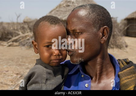 AKAL Dorf in der Nähe von BADERA WESTERN SOMALIA 2. März 2006 Mohammed Gabow 50 hält seinen Sohn, 4, der Anzeichen von Mangelernährung ist Stockfoto