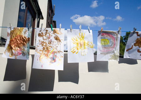 Kinder bunte Gemälde hängen zum Trocknen an einem sonnigen Tag Stockfoto