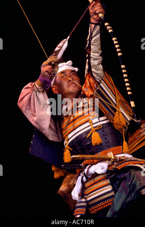 Ein japanischer Krieger Schauspieler schießen Pfeil und Bogen im Bogenschießen-Ritual-Bühnen-Performance und tragen Tracht aus Japan Stockfoto