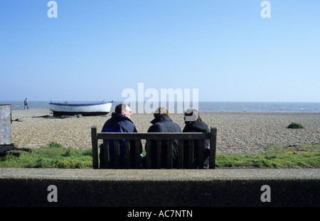 Leute sitzen auf Bank in Aldeburgh Seafront in Großbritannien Stockfoto