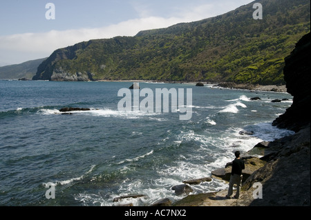 Einsamer Mann neben Meer, Einsiedelei von San Juan de Gaztelugatxe, Pais Vasco (Baskenland), Nord-Spanien, Europa Stockfoto