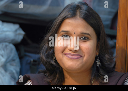 Indische Frau lächelnd mit offenen Haaren und Bindi auf Stirn und schaut in die Kamera Modell veröffentlicht Stockfoto