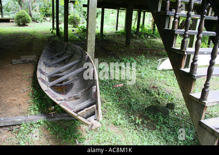 Ein kleines Boot unter einem malaiischen Haus in Sarawak, Malaysia. Stockfoto