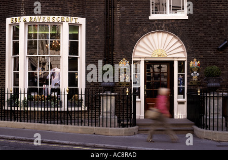 Frau Shopper in Bewegungsunschärfe vorbei exklusive Kleidung Shop, Burlington Gardens, Mayfair, London, England Stockfoto