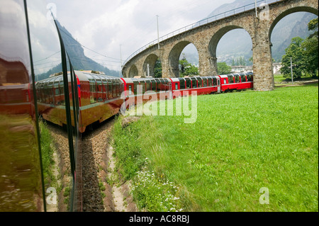 der Bernina-Express-Zug in der Schweiz von Chur nach Tirano in Italien Unterquerung des Brussio Viadukts Stockfoto