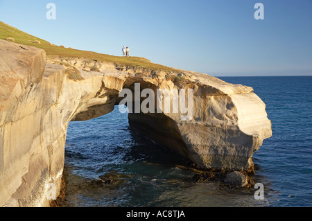 Paar auf natürlichen Bogen Tunnel Beach Dunedin Südinsel Neuseeland Stockfoto